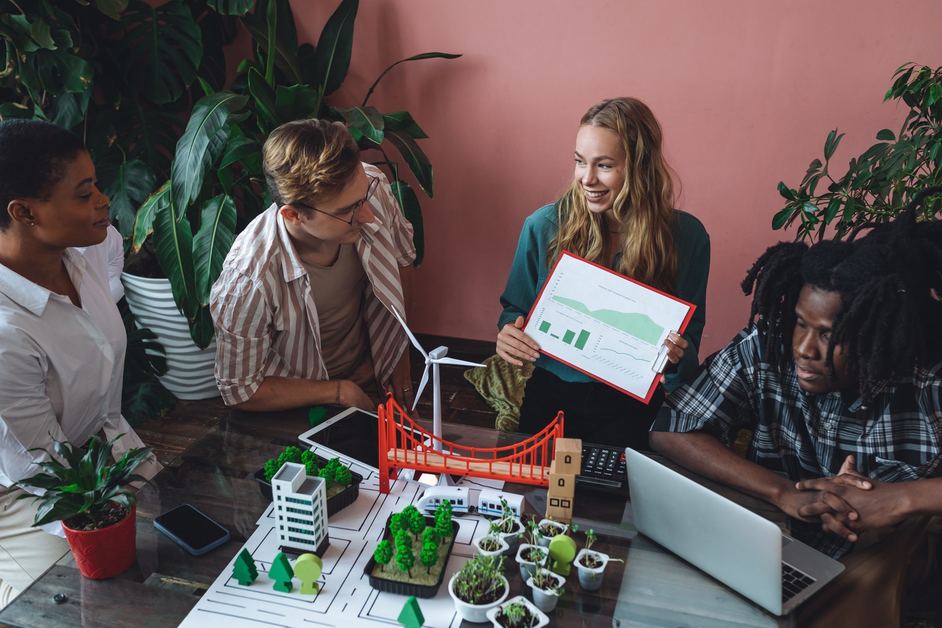 International diverse group of students working on modern urban architecture project with renewable green energy source, alternative electricity, waste recycling. Brainstorming ideas, business plan